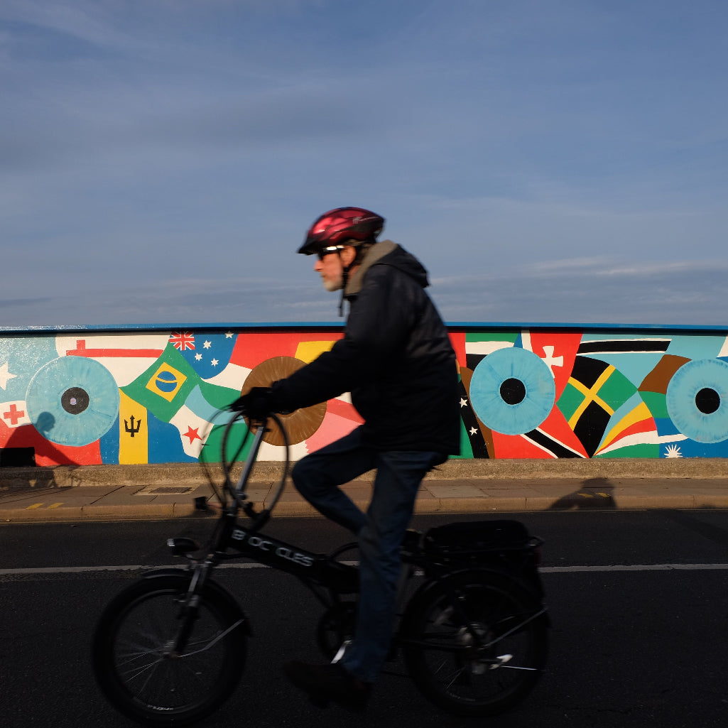 cyclist on mill road bridge with mural in the background