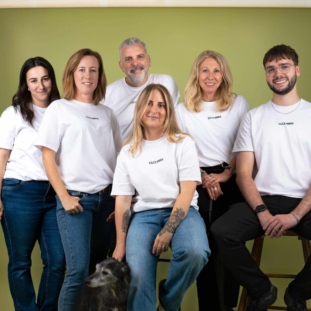 Group of people posing for a photo in a studio setting with green floor and white walls.