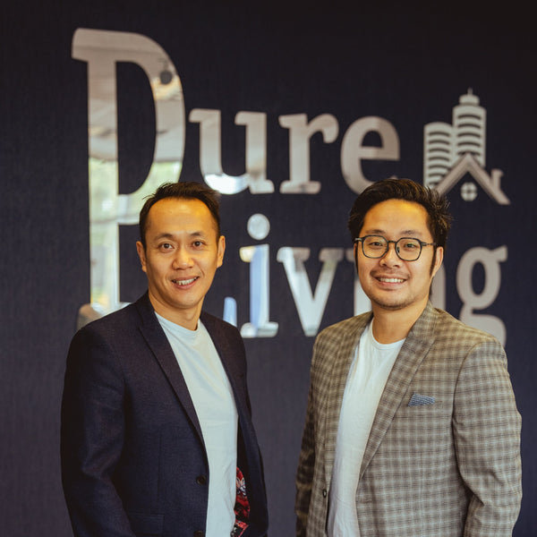Two men standing in front of a 'Pure Living' sign.